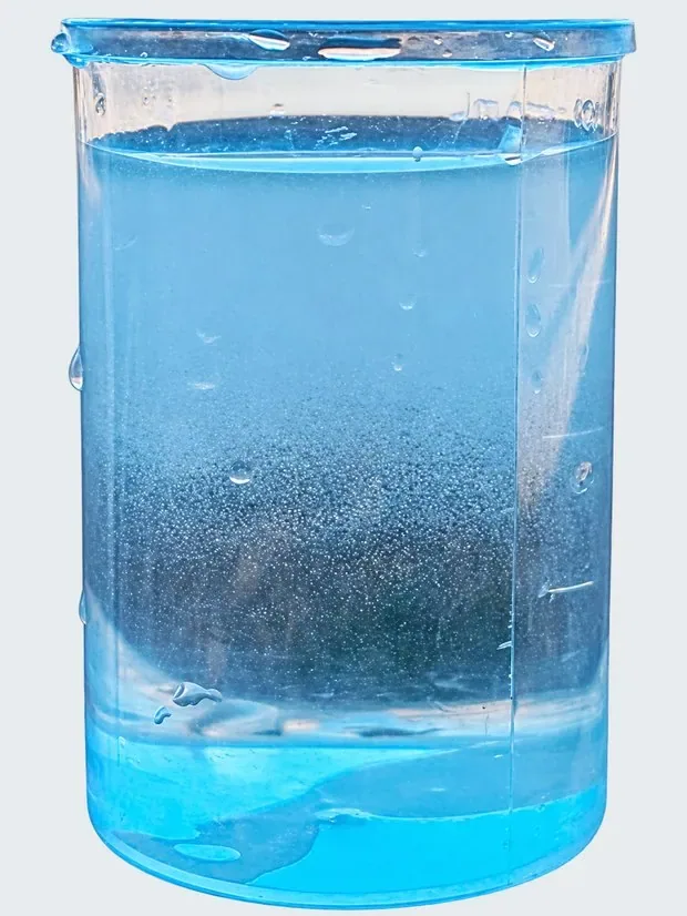 Vaso con agua tratada en el que se aprecian las microburbujas