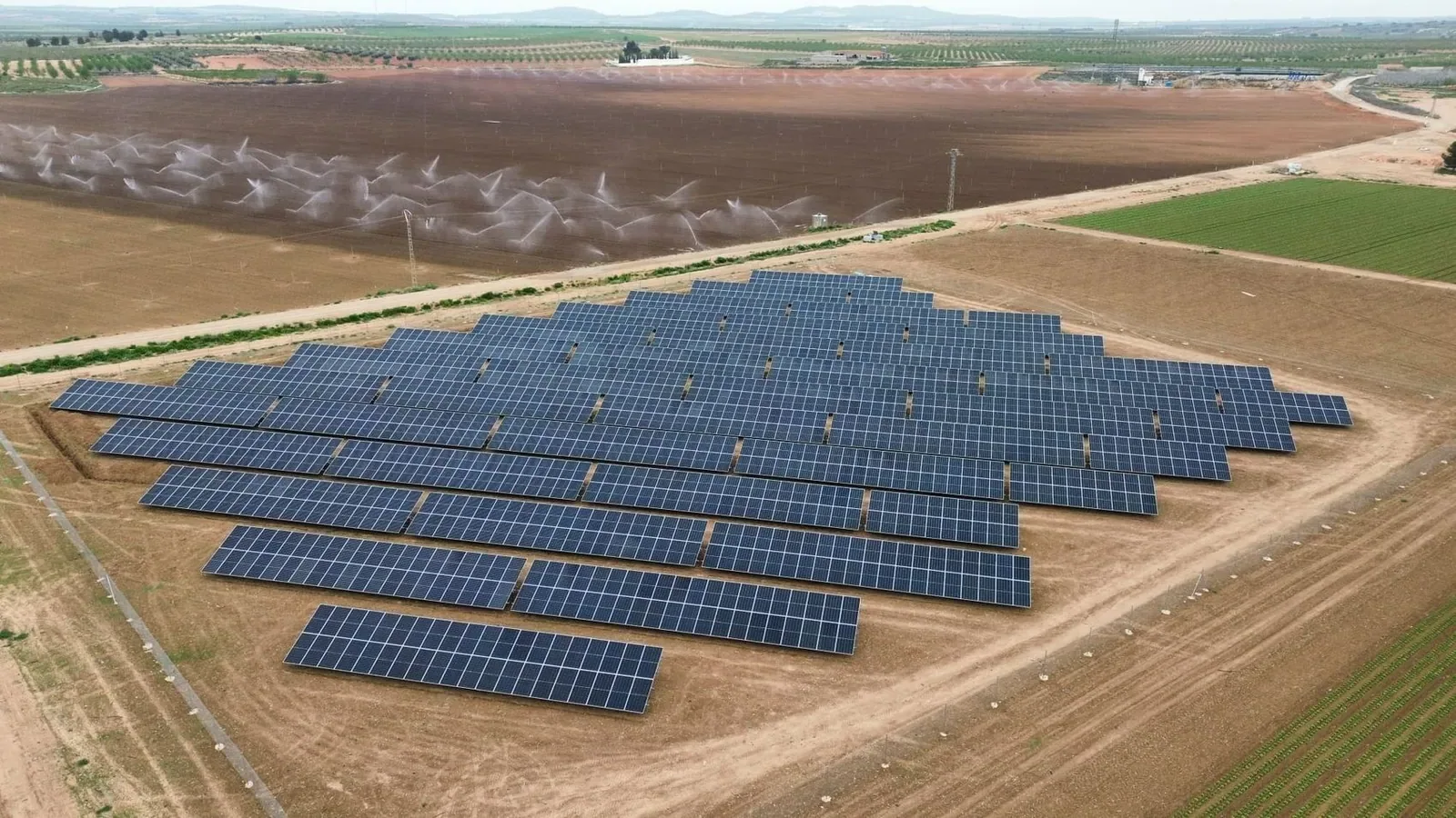 Planta fotovoltaica junto a una parcela de riego, vista aérea