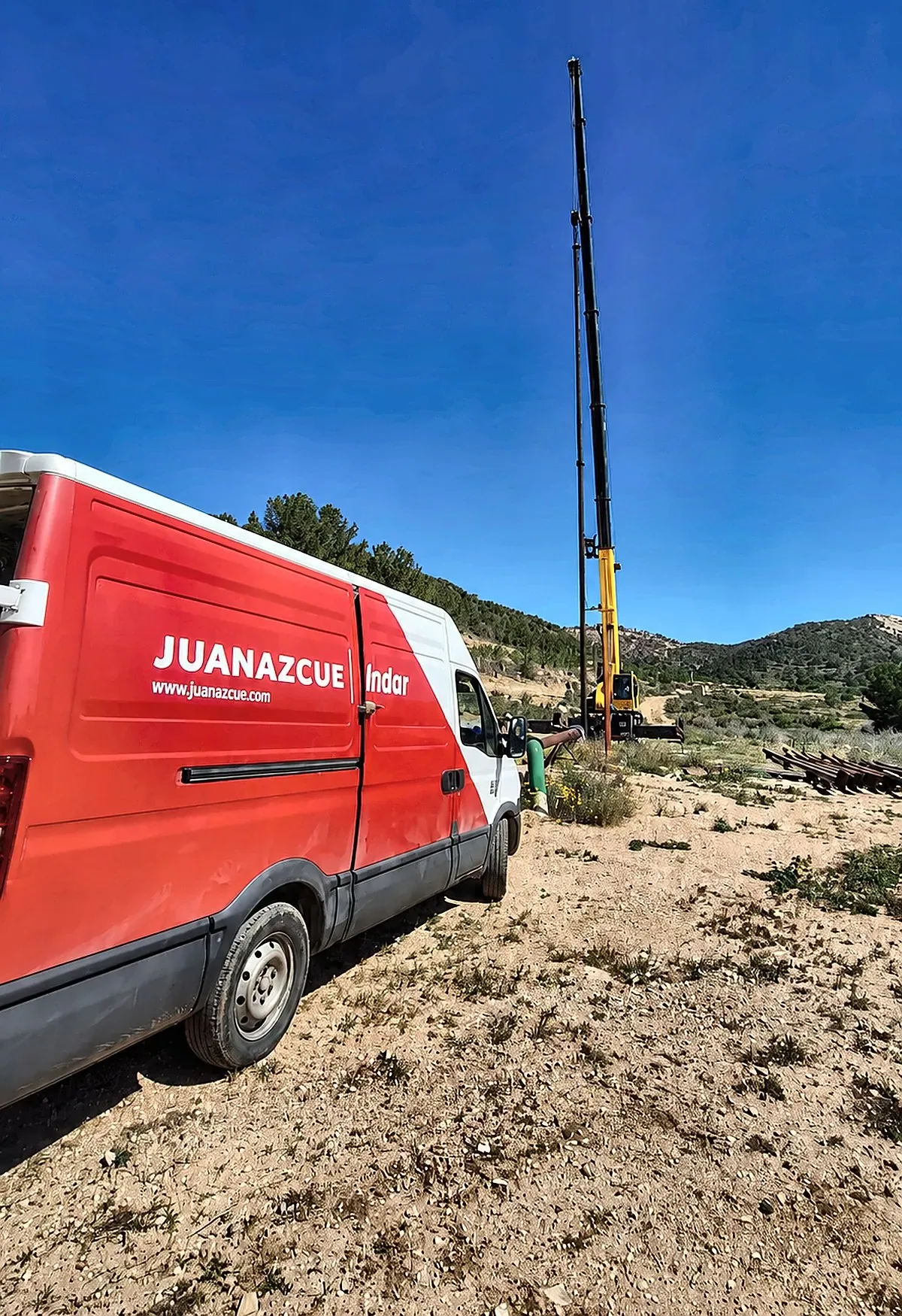 Furgoneta rotulada de Juan Azcue junto a la captación, con la grúa desplegada al fondo sobre la vertical del pozo