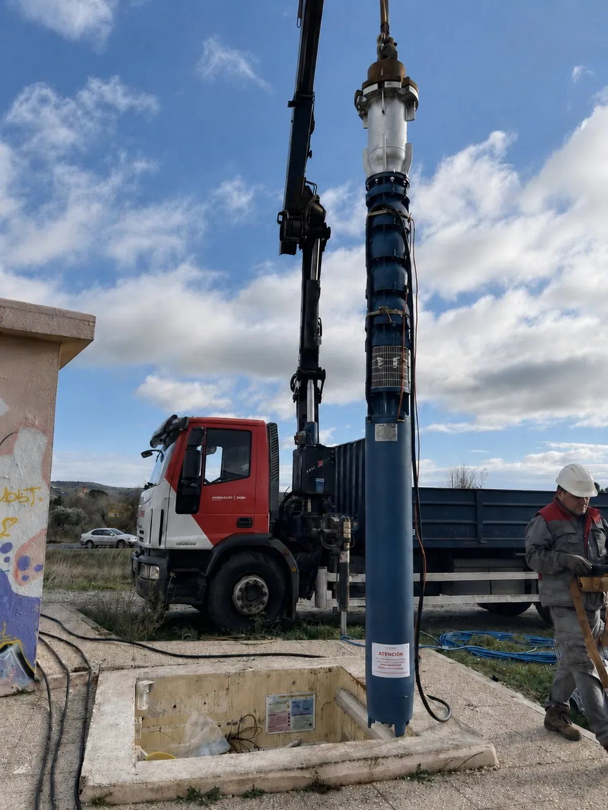 Grupo motor-bomba sumergible suspendido de la grúa sobre la vertical de la captación, momentos antes de su descenso